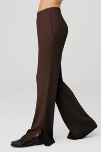 Dettaglio dei pantaloni yoga in maglia a costine marrone scuro con spacco laterale
