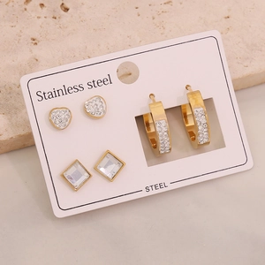 Macro detail of three-pair stainless steel earring set with heart and crystal studs