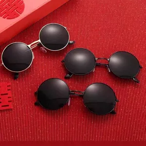 Three retro round metal sunglasses in gold and black frames on red festive background
