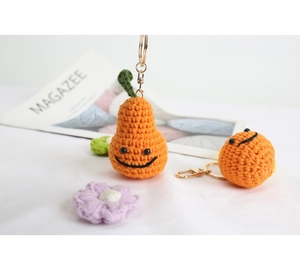 Dettaglio macro di ciondoli a forma di frutta sorridente all'uncinetto con portachiavi