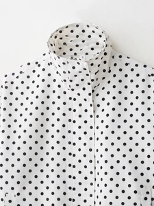 Détail de la veste blanche à pois noirs avec col montant et étiquette de taille S