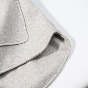Vue macro détaillée du tissu en mélange de laine gris clair montrant le bord de l'ourlet