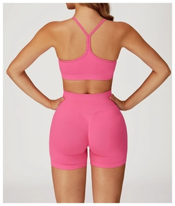 Detailed back view of pink seamless high-stretch yoga bra with thin T-strap and ribbed waist