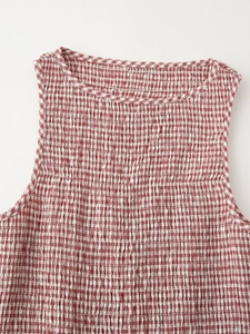 Detail of red and white checkered smocking texture on sleeveless round neck midi dress