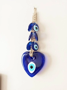 Detailed view of handmade Evil Eye heart glass pendant with woven rope hanging decoration