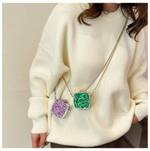Detail of mini acrylic evening bags in purple and green sequins with chain straps