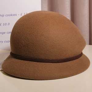 Dettaglio cappello cloche in feltro di lana marrone con fascia in pelle e stile retrò