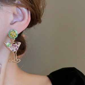 Detail view of summer lime pearl cocktail glass earrings on a model with sparkling stones