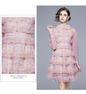 Détails de la robe en dentelle rose avec col Claudine et broderies à volants chic