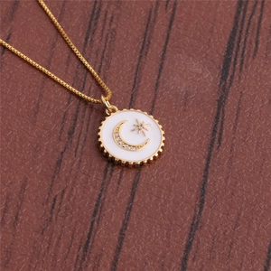 Detailed macro view of a gold moon and star pendant on a red leather background