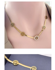 Detail of gold tree of life necklace with pavé crystal charms and flat blade chain