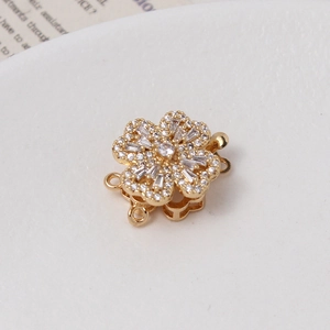Macro detail of gold-plated rotatable flower clasp with micro-set cubic zirconia stones
