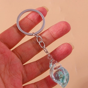 Close-up of a conch shell keychain featuring a mini ocean resin landscape inside