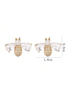 Macro shot showing exact dimensions of golden bee studs with cubic zirconia wings