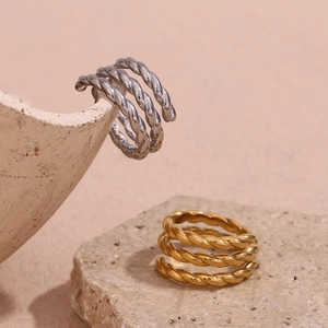 Artistic display of triple-layered twisted spiral rings in gold and silver finishes