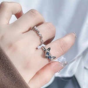 Detail view of silver cat-shaped ring with blue eyes and twisted band on hand