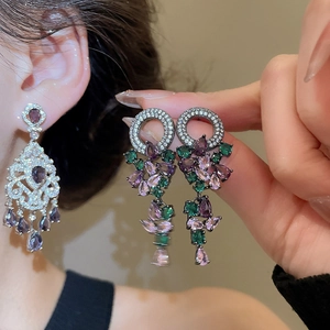 Close-up of vintage style earrings with purple teardrop crystals and silver craftsmanship
