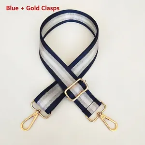 Detail of blue and silver striped nylon bag strap with polished gold metal swivel hooks