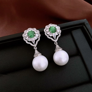 Detailed shot of vintage silver earrings with green cat eye stone and white pearls