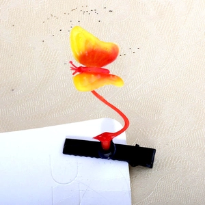 Detail of creative butterfly spring hair clip with yellow gradient wings and metal duckbill