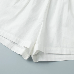 Gros plan détaillé de l'ourlet du short blanc en coton et texture des coutures de qualité