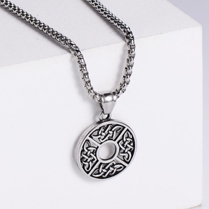 Celtic knot stainless steel pendant necklace on a geometric display stand in matte silver