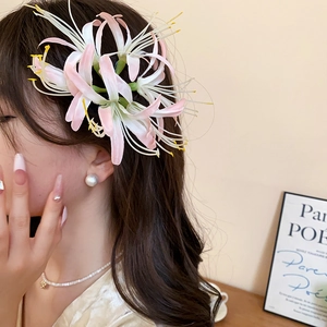 Detail view of pink gradient floral hair clip with realistic stamens on model