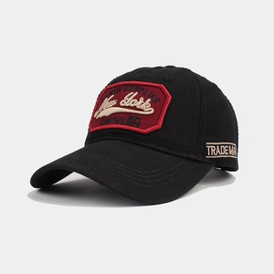 Detail of red New York embroidery and white stitching on a black cotton baseball cap