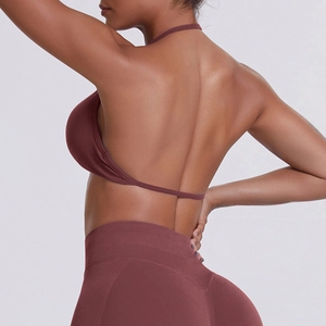 Detail view of seamless mauve sports bra with halter neck and V-shaped yoga leggings