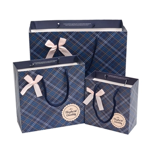 Dark blue plaid gift bags with pink ribbon bow in three sizes and woven handles