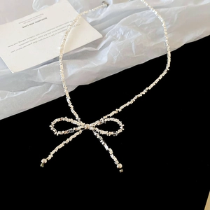 Vue détaillée d'un collier avec nœud métallique argenté et maillons carrés élégants