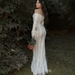 Elegante abito lungo in pizzo bianco con spalle scoperte e motivi floreali nel bosco