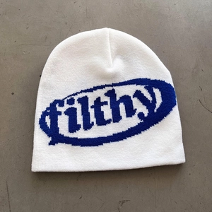 Detailed knit texture of white beanie featuring blue filthy jacquard letter embroidery