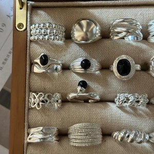 Collection of S925 sterling silver rings with black gemstones in a linen jewelry box