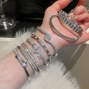 Detail of 18k gold plated silver bracelets featuring zircon stones and heart buckle design