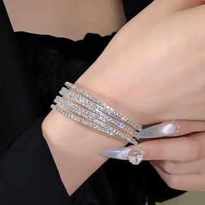 Detailopname van een luxe zilveren kruisarmband met lagen van schitterende zirkonia