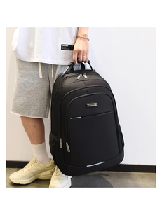Detail of a black business backpack featuring durable top handle and metal zipper accents