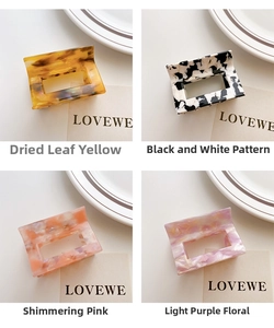 Close-up of four patterned square acetate hair claws in amber, cow print, pink and marble