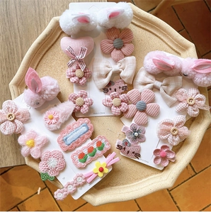 Detailset aus rosa Plüsch-Hasen- und Blumen-Haarspangen für Mädchen auf Steintablett
