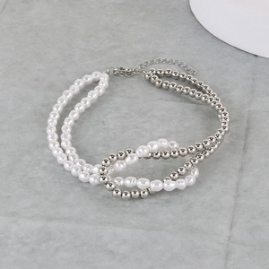 Detail of beaded pearl necklace featuring a knotted center and silver lobster clasp