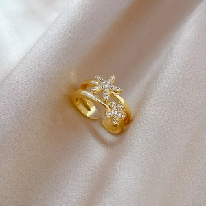 Macro shot of gold plated starfish ring with micro-set zircon on champagne silk fabric