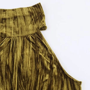 Dettaglio del tessuto in velluto verde oliva con elegante trama a pieghe e increspature