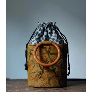 Vintage yellow bucket bag with brown leaf patterns and circular wooden handle