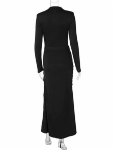 Detail view of the back side of a slim fit long sleeve black maxi dress on a model
