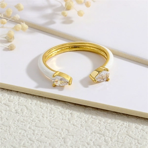 Detail view of 18K gold plated ring with white enamel and pear cut cubic zirconia gems