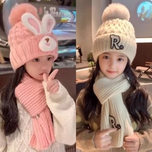 Detail of baby winter knit hat with cute rabbit ears and embroidered letter R patch