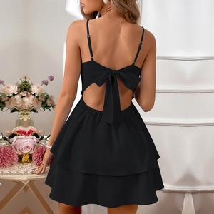 Detail of backless black dress featuring elegant bow-tie ribbons and ruffled layered hem