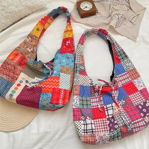 Close-up of bohemian patchwork canvas tote bag featuring floral patterns on white texture
