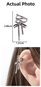 Detail view of silver bow ear cuff with dimensions 2.86cm by 1.31cm and model wearing view