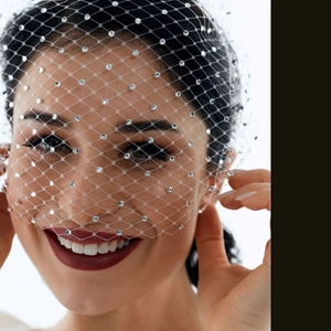 Close-up of white bridal birdcage veil headband with sparkling rhinestone detailing